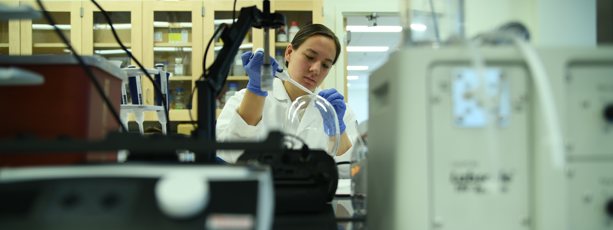 A researcher in her lab using a pipette