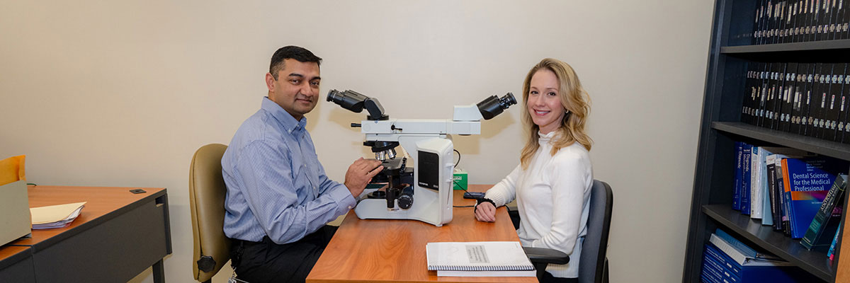 Drs. Easwar Natarajan and Jenna Ward portrait with microscopes